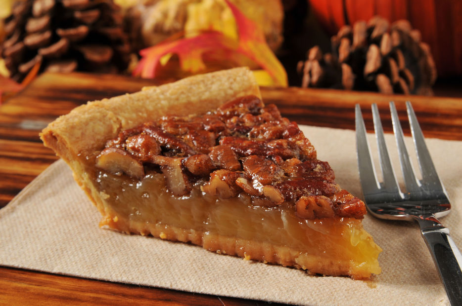 A slice of pecan pie with a festive autumn, Thanksgiving background